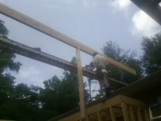 Carpenter setting a ridge beam over a new addition frame — Ice Dam Removal by Roofing Brothers in Cambridge Springs