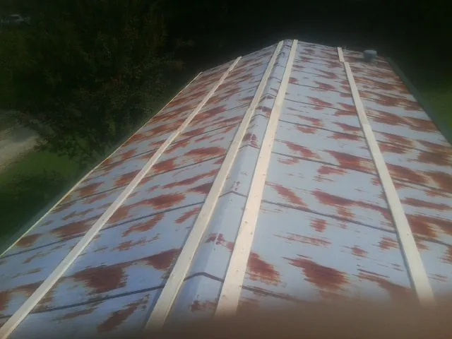 Rusted metal roof panels with new wood purlins before replacement — Storm Damage Roof Repair in Cambridge Springs by Roofing Brothers