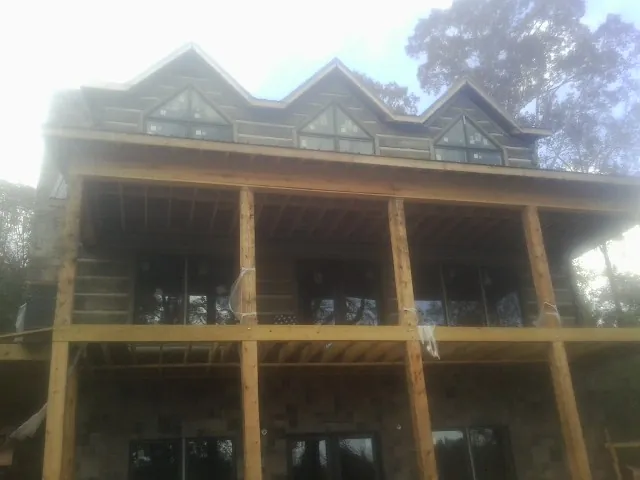 Dormers and porch framing on a large log home under construction — Roof Coating work by our crew in Cambridge Springs