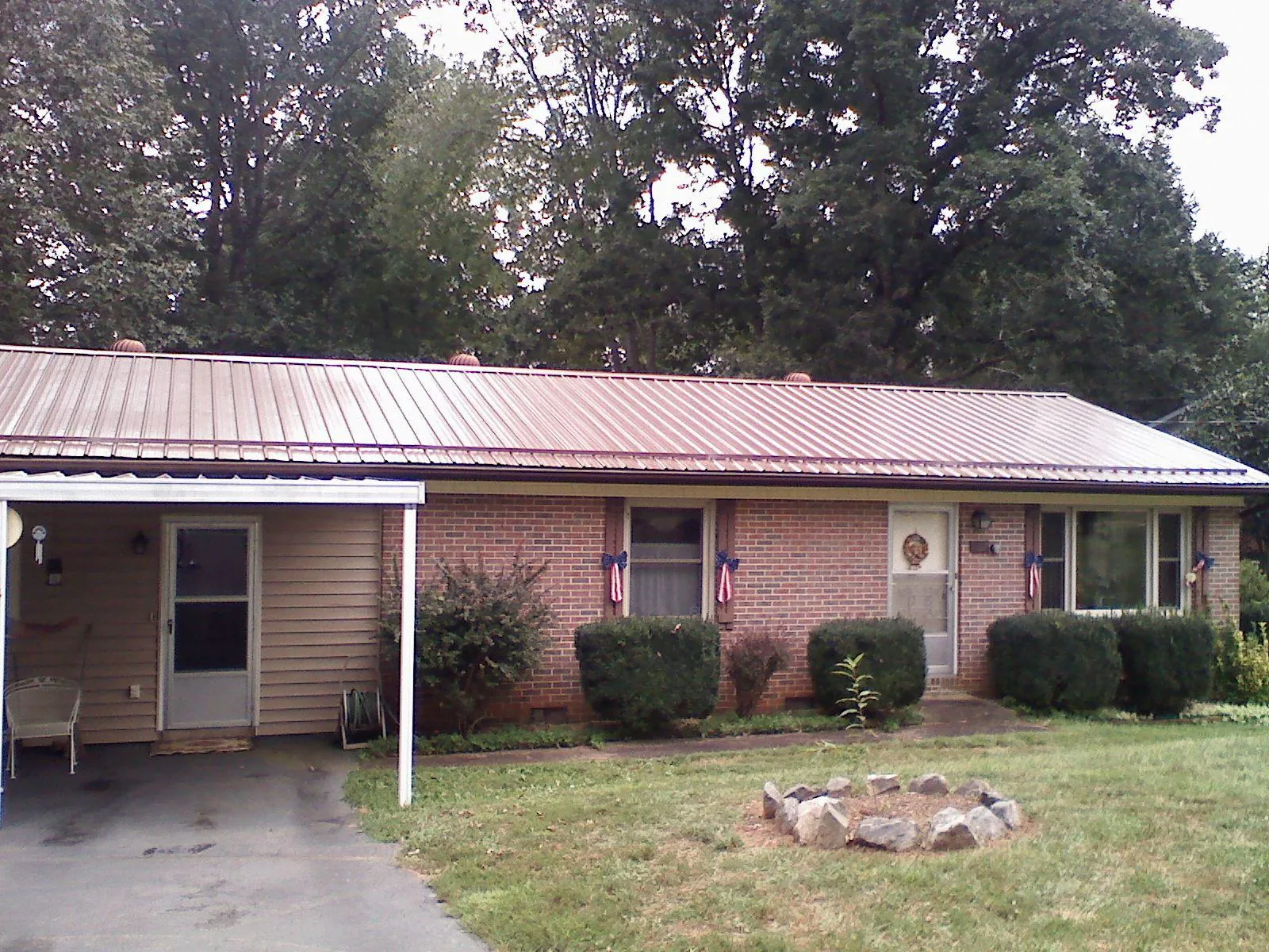 Bronze metal roof and carport on a brick ranch home — Roof Repair work by our crew in Cambridge Springs